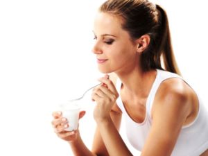 Женщина пьет йогурт